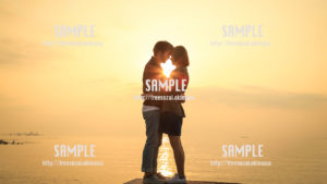 【沖縄】朝日に包まれるカップル 写真素材